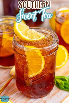 a mason jar filled with iced tea and lemon slices on top of a wooden table