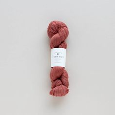 a skein of red yarn sitting on top of a white surface