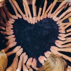 a group of women holding their hands together in the shape of a heart