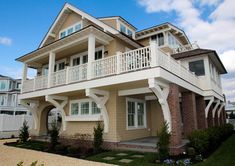 a two story house with white balconies on the second floor