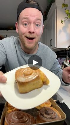 a man is holding up a plate with some food on it in front of him