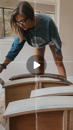 a woman sanding up furniture with a hammer