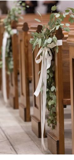 rows of wooden pews decorated with greenery and ribbons