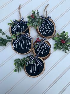 four christmas cookies with the words noel, merry, and joy hanging from twine