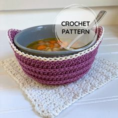 a crochet bowl with a spoon in it sitting on top of a placemat