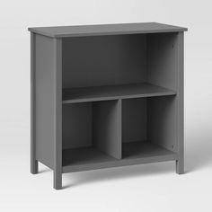 a gray shelf with two open compartments on each side and one closed drawer at the top