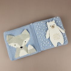 two crocheted polar bears and a fox on a blue blanket with white dots