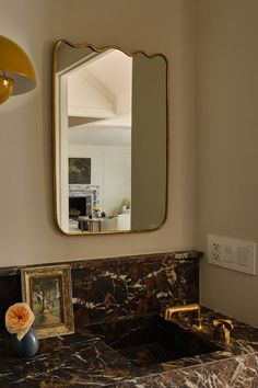 a bathroom sink with a mirror above it and two pictures on the wall next to it