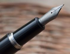 a close up shot of the nib of a fountain pen on a brick surface