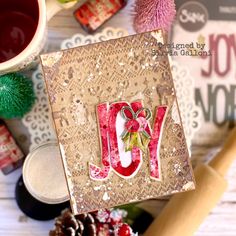 a card with the word joy on it and some other crafting supplies around it