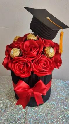 a graduation cap on top of a cupcake with roses and chocolates in it