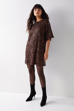 All-over sequin embellishments add glamorous texture   Relaxed, slouchy fit with batwing sleeves   Round neckline and straight hem for easy styling   Lined to prevent transparency   Lightweight, pull-on style with no fastenings  This sequin-embellished slouch tee shirt dress from Warehouse is an elegant choice for special occasions. The all-over sequins create a glamorous, textured look while the relaxed, batwing sleeve silhouette keeps the style effortlessly chic. Pair with sheer tights and heels for a refined evening ensemble. The round neckline and straight hem allow for versatile styling. With its pull-on design and lightweight lining, this dress offers an easy-to-wear option for your next formal event. Let the dazzling embellishments be the focus and keep the rest of your look mini Sequin T Shirt, Sequin T Shirt Dress, Wedding Guess Dress, Wedding Guess, Tights And Heels, Sleeve Silhouette, Friday Outfit, Guess Dress, Sheer Tights