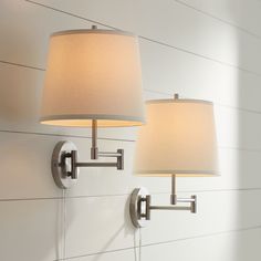 two lamps mounted on the wall next to each other in a room with white walls