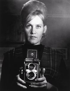 a woman holding an old camera in her hands