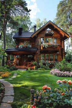 a log house with lots of flowers in the front yard and walkway leading up to it