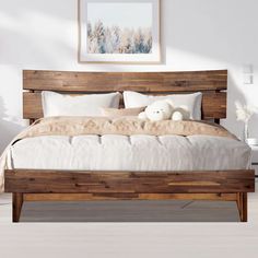 a bed with white pillows and wooden headboard