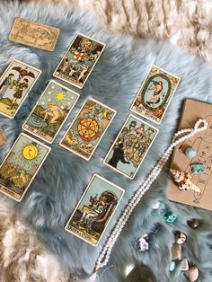 the tarot cards are laid out on a fur covered surface next to beads and other items