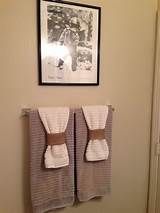 two towels are hanging on the wall next to a framed photo