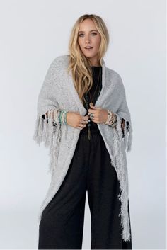 Drape yourself in the Moon Shadows Ruana Wrap and feel stylishly boho from day to night! This cozy-knit wrap features a loose and flowy silhouette, a beautiful triangular shape, and adorable tassel trim for a unique and versatile look. Infuse your wardrobe with some boho flair! Details: One size: 33 1/2"W x 86"L 100% Acrylic Hand wash cold, Lay flat to dry Import Cheap Bohemian Winter Shawl, Bohemian Shawl For Fall Layering, Bohemian Knit Poncho With Fringe, Casual Poncho With Tassels For Festivals, Beach Shawl With Tassels One Size, One Size Tasseled Shawl For The Beach, Beach Shawl With Tassels, Hippie Shawl For Fall, Hippie Shawl One Size For Fall