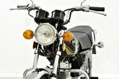 the front end of a motorcycle with its lights on and headlight turned off, against a white background