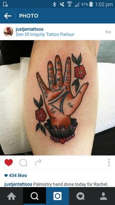 a tattoo on the leg of a person with a hand and flowers