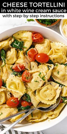 a white bowl filled with pasta and spinach