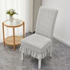 a chair with a ruffled seat cover next to a table