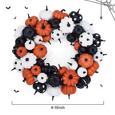 a halloween wreath made out of plastic pumpkins and black and white spider webs