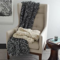 a chair with a blanket on it next to a table