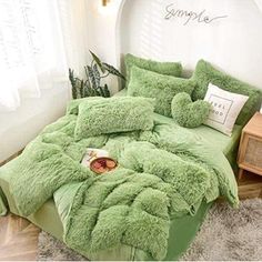 a bed covered in green fluffy pillows and blankets