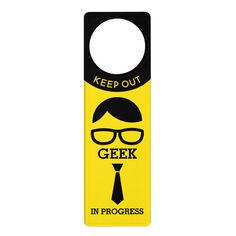 a yellow door hanger with the words geek at work on it and a man's face in glasses