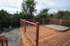 a wooden deck with metal railings and a dog bed on the bottom part of it