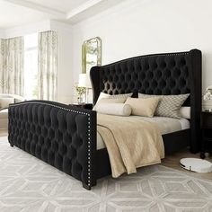 a large black bed sitting in a bedroom on top of a white carpeted floor