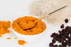 a white bowl filled with orange colored powder next to a pile of fluffy white stuff