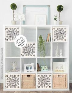 a white book shelf filled with lots of books and plants in front of a mirror