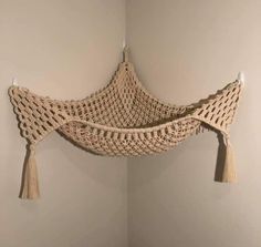 a crocheted hammock hanging on the wall with tassels attached to it