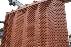 a large brick wall is being constructed into the shape of a giant building with many holes in it