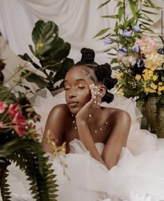 a woman in a white dress with flowers on her head and hands to her face