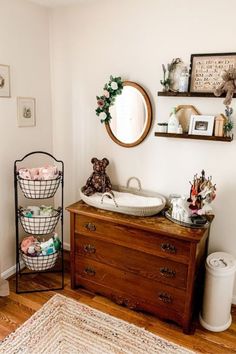 a wooden dresser sitting next to a mirror in a room on top of a hard wood floor