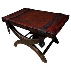 an old wooden table with leather straps on the top and bottom, against a white background