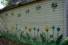 a painted mural on the side of a building with yellow and white dandelions