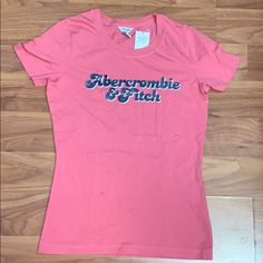 Brand New With Tags Attached Vintage Abercrombie & Fitch Size Medium Pink T-Shirt With Iron On Sparkle Retro Logo Small Stain On Front (See Photo) Abercrombie T Shirt, Acdc Shirt, Abercrombie (women), Baby Tee Shirts, Velvet T Shirt, Cropped Tee Shirt, Red Polo Shirt, Baby Graphic Tees