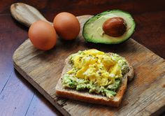 an avocado, egg and bread on a cutting board with the words perfecto