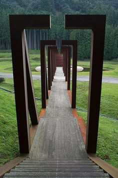 a wooden walkway in the middle of a grassy field