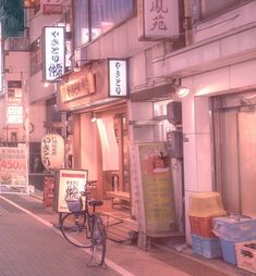 a city street at night with signs and bicycles parked on the sidewalk