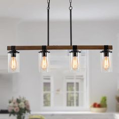 three lights hanging from a wooden beam in a kitchen