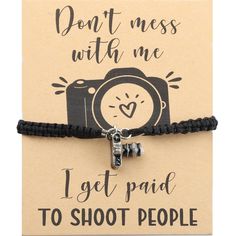 a black cord bracelet with a camera charm on it that says, don't mess with me i get paid to shoot people