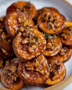 a white plate topped with sliced peaches and nuts