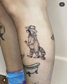 a woman's legs with tattoos on them and a dog sitting in a bathtub