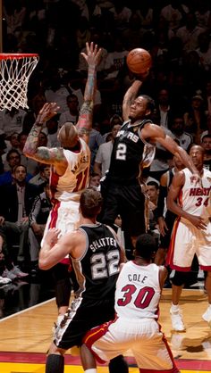 a group of men playing basketball against each other